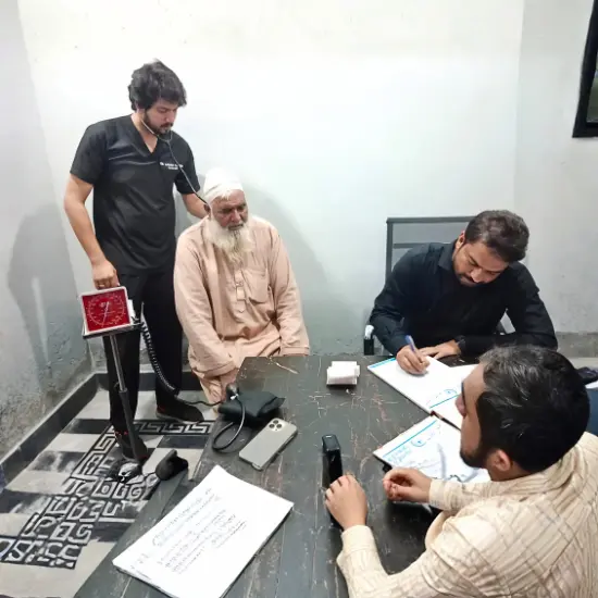 Dr Gulfam Checking Patient on free camp at Hashmi Hospital